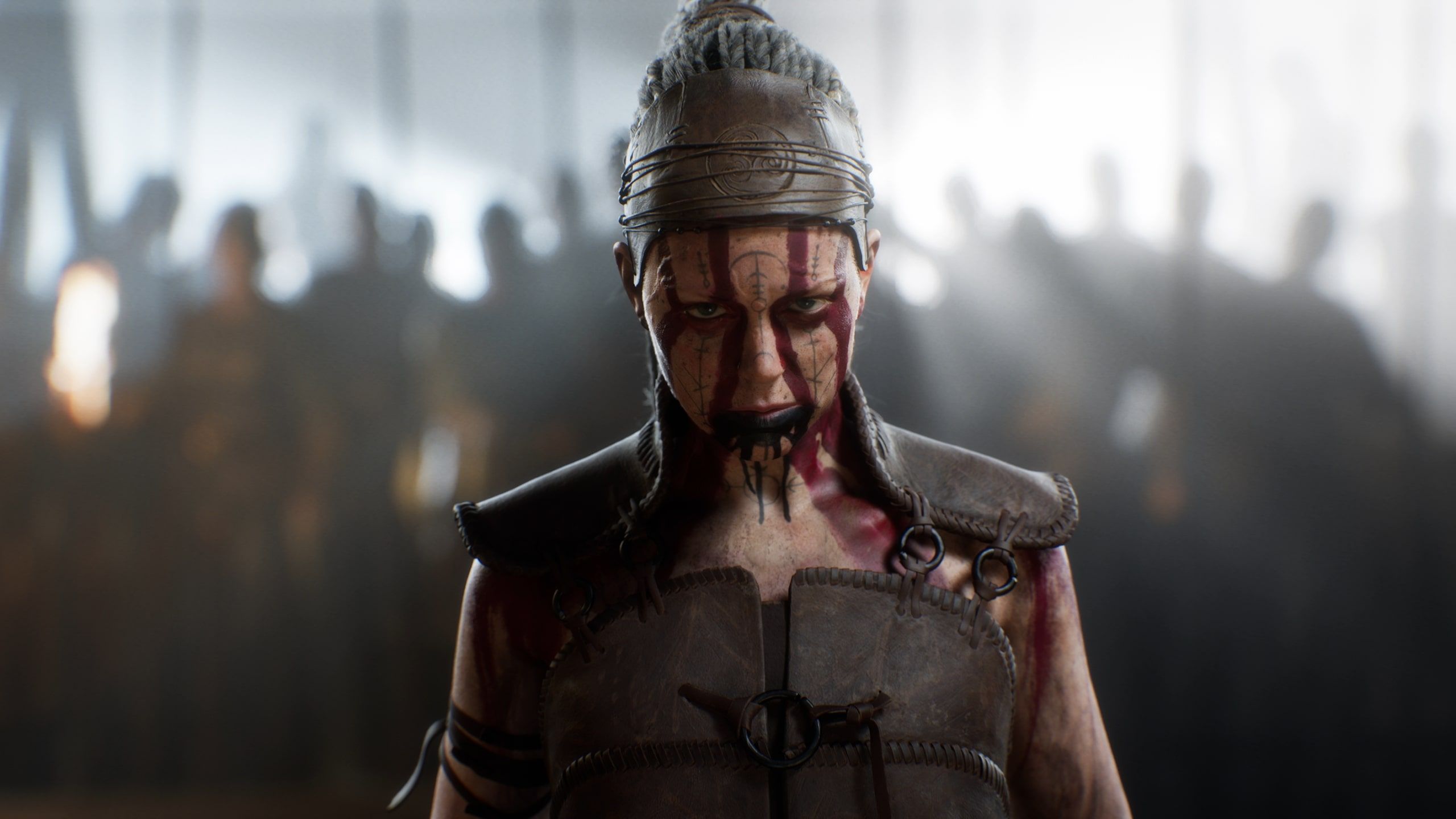 Senua in battle dress with blurred battle scene behind